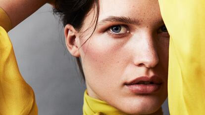 La modelo Julia van Os está maquillada con los polvos sueltos Fabulous Skin, para unificar la tez (tono Sunny Ivory); con el colorete líquido Good Girl Blusher (tono Plum Tulip, 1092), la sombra de ojos Chic Mono Eyeshadow Mate (tono Chocolate 004) y con unos toques del labial traslúcido Fabulous Kiss (tono Fabulous Nude, 144); todo de HERRERA BEAUTY. Lleva camisa anudada al cuello de CAROLINA HERRERA.