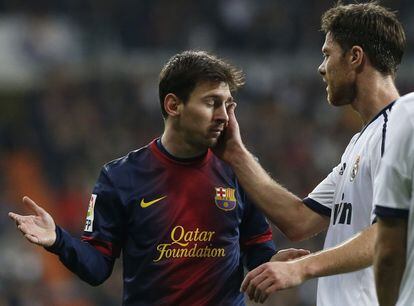 Xabi Alonso toca la cara de Lionel Messi.