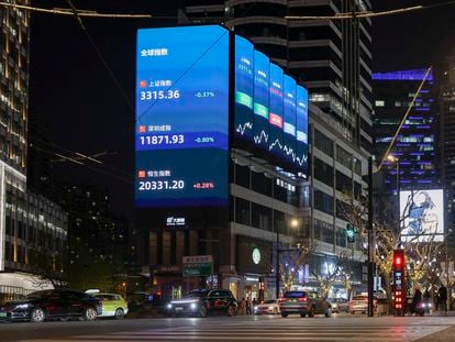 Imagen de una calle de Shanghai en la que se aprecia en una pantalla la evolución de los índices chinos.