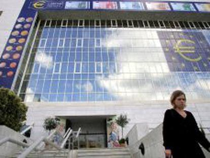 Una mujer chipriota camina delante de un enorme s&iacute;mbolo del euro en la fachada del Banco Central en Nicosia, Chipre. 