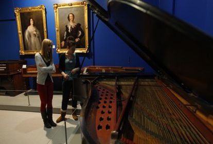 Dos alumnas del conservatorio observan el Steiner que se encuentra en el museo. Al fondo, dos retratos de alumnos de canto del centro que llegaron a ser figuras del bel canto, como María Oreiros.