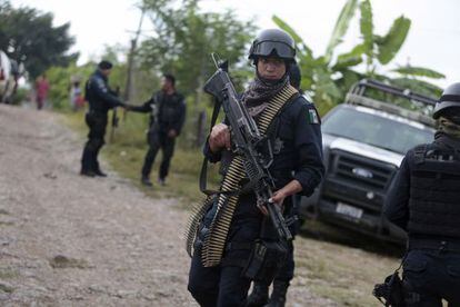 Un policía mexicano vigila los alrededores de las fosas halladas en Iguala.