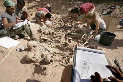 Un equipo de antropólogos y arqueólogos limpia los esqueletos de la fosa de La Andaya (Lerma) antes de trasladarlos al laboratorio.