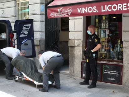 Dos trabajadores de la Funeraria Servisa recogen los cuerpos sin vida del hostal de la calle Postigo de San Martín de Madrid, donde la Policía Nacional ha hallado esta mañana los cadáveres de una mujer de 35 años y su hijo de 5 años.