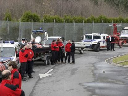 Agentes de la Ertzaintza esperan junto a sus veh&iacute;culos.