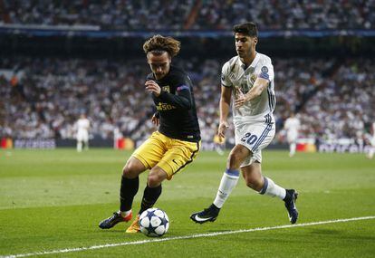 El jugador del Atlético de Madrid Antoine Griezmann controla el balón ante Marco Asensio del Real Madrid.