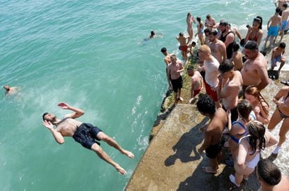 A group of people cool off in the sea in Brighton.