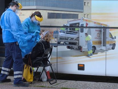 Unos enfermeros realizan un test a una mujer en el exterior de una de las doce unidades móviles que la Junta de Castilla y León ha contratado para hacer test de antígenos a la población que tenga síntomas durante todo el mes de enero, este martes en Valladolid.