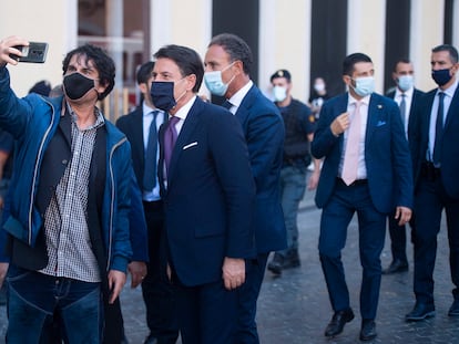 El primer ministro italiano Giuseppe Conte posa para una fotografía con un admirador.