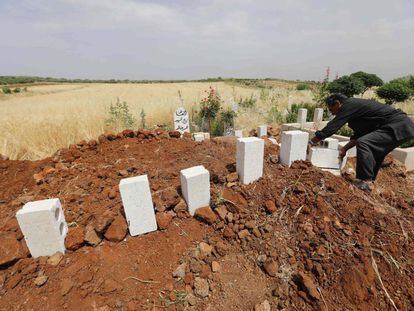 Un sirio coloca ladrillos sobre las tumbas de cinco civiles muertos en bombardeos sobre el poblado de Kafr Aweid, en la provincia de Idlib.