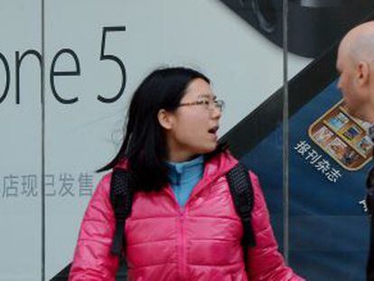 Una pareja camina por delante de una tienda de Apple en Pek&iacute;n (China)