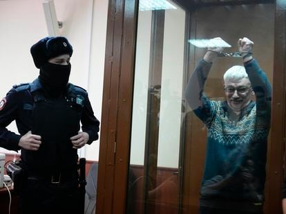 El activista ruso Oleg Orlov muestra las esposas mientras comparece ante un tribunal de Moscú, este martes.