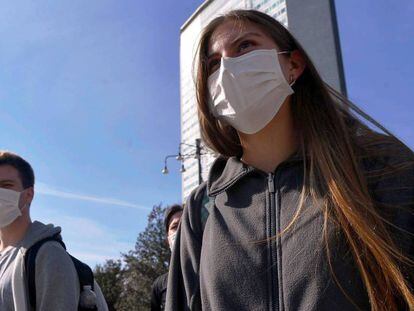Un hombre y una mujer pasean por Milán con mascarillas quirúrgicas. En vídeo, agotadas las mascarillas en las farmacias españolas