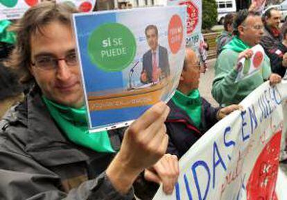 Integrantes de la Plataforma de Afectados por la Hipoteca de Bizkaia (PAH), muestran pancartas durante el escrache en Bilbao, cerca del domicilio del diputado del Partido Popular Leopoldo Barreda. EFE/Archivo