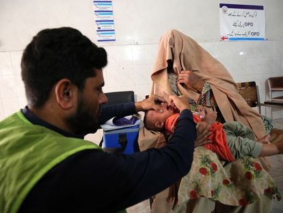 Un trabajador sanitario pakistaní administra gotas antipoliomielíticas a un niño durante una campaña de vacunación en el hospital público Lady Reading de Peshawar (Pakistán), el 2 de octubre.