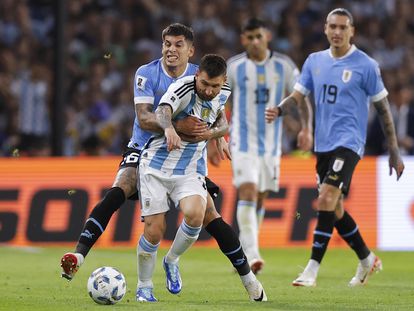 Lionel Messi disputa el balón con Mathías Olivera, en el duelo entre Argentina y Uruguay en el estadio La Bombonera en Buenos Aires.