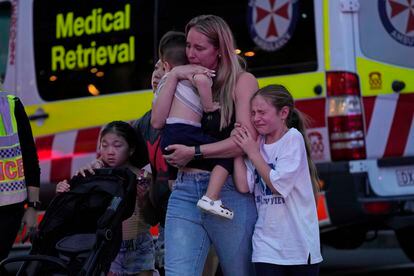 Una familia llora al salir del centro comercial Westfield donde un atacante mató a puñaladas a varias personas este sábado en Sydney.