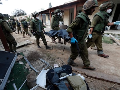 Soldados israelíes retiran cadáveres del kibutz de Kfar Aza atacado por Hamás, el pasado martes.