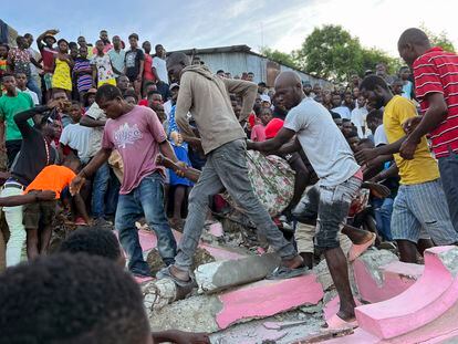 People carry an injured person away from a home that collapsed due to an earthquake in Jeremie, Haiti, on June 6, 2023.