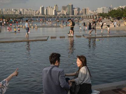 Una pareja surcoreana en un parque al lado del r&iacute;o Han, en Se&uacute;l.