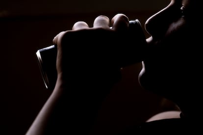 A girl drinks a can of energy drink.