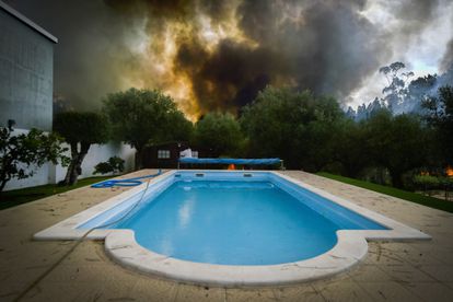 Un incendio arde cerca de una piscina durante un incendio forestal en el pueblo de Lavradio, Ourem, Portugal, este miércoles.