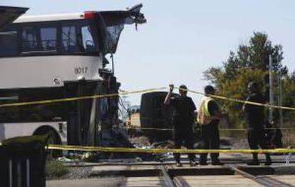 Varios policías trabajan en el lugar donde se produjo una colisión entre un autobús de dos pisos y un tren de pasajeros de la compañía Via Rail que se dirigía hacia Toronto, en un paso a nivel situado en las cercanías de Ottawa (Canadá), este miércoles 18 de septiembre de 2013.