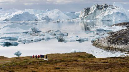 Un grupo de turistas frente al fiordo helado de Ilulissat, un lugar en la costa occidental de Groenlandia declarado patrimonio mundial de la Unesco.