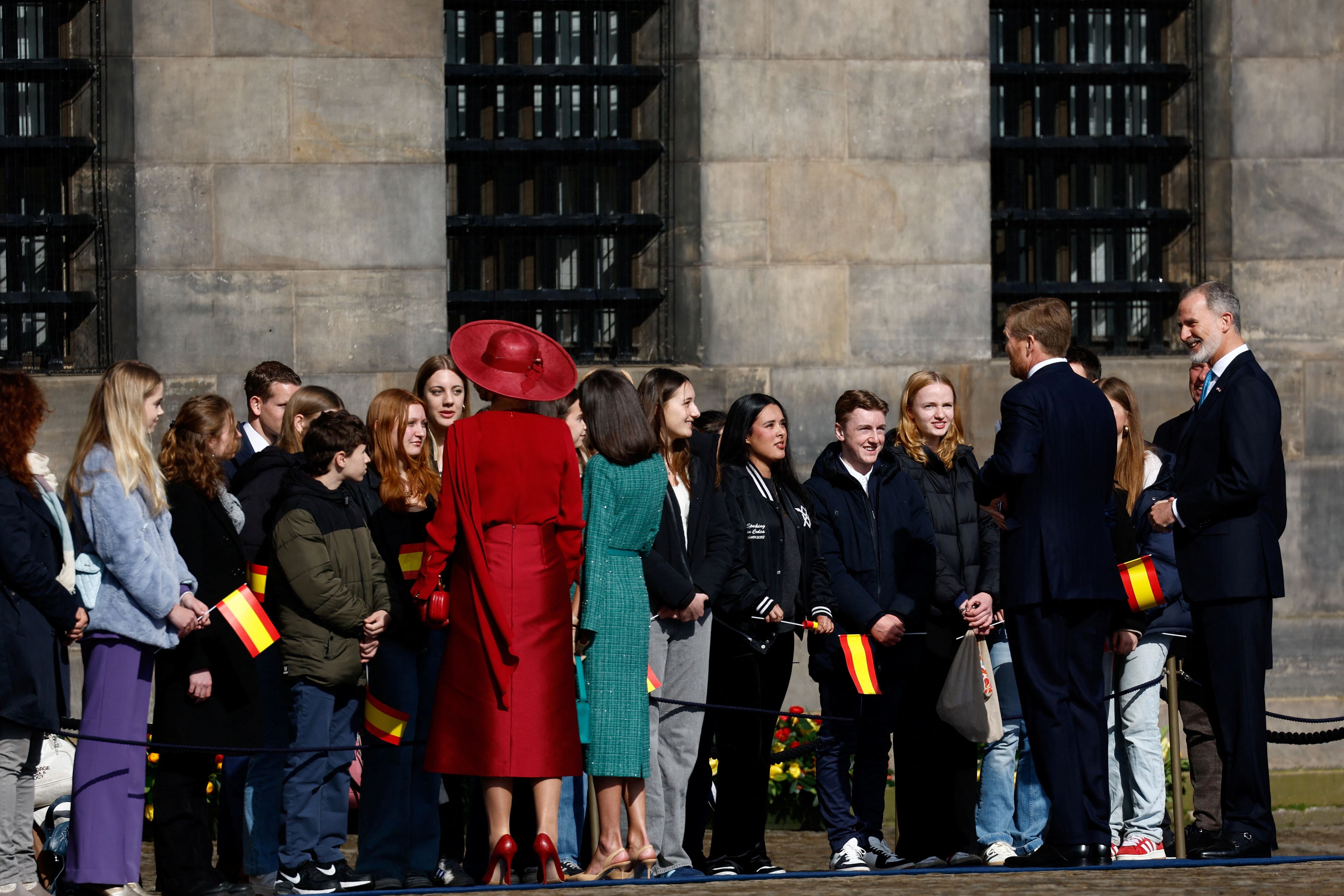  Los reyes de Países Bajos y de España conversan con un grupo de ciudadanos que se acercaron a ver la ceremonia de bienvenida en la Plaza Dam de Ámsterdam.