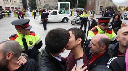 Parejas gais se besan al paso del 'papamóvil' por las calles de Barcelona.