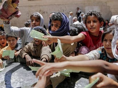 Un grupo de niños presenta documentos a una ONG local para recibir su ración de comida, en abril de 2017 en Saná.