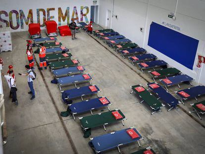 Efectivos de Cruz Roja preparan camas en uno de los pabellones del puerto de Valencia para acoger a los migrantes. 