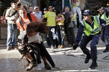 Un policía golpea a una fotógrafa durante una carga policial en Lisboa.