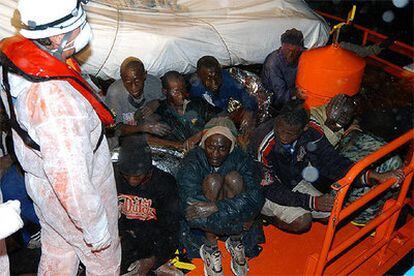 Varios inmigrantes en la cubierta de la embarcación Mizar de Salvamento Marítimo.