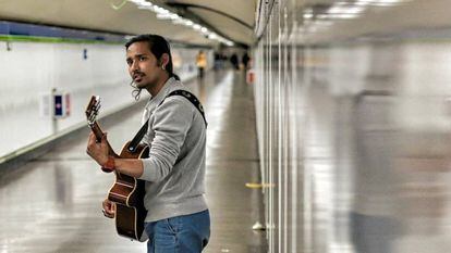 Kishan Adhikari toca la guitarra en el metro de Madrid.