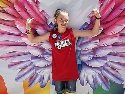 Savannah posando delante de un cartel del Utah Pride Festival.