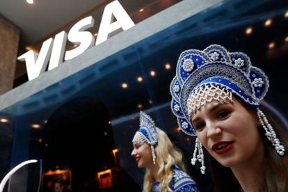 Two hostesses greet the winners of a contest organized by Visa at the soccer World Cup, in July 2018 in Moscow.