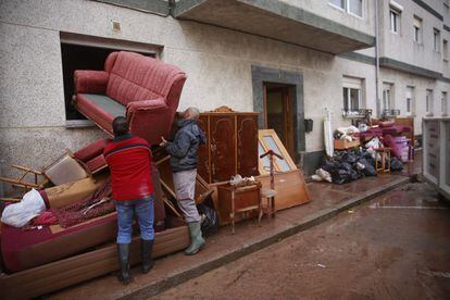 El temporal Fabien, cuyo paso por la Península será rápido, preocupa por el viento. En la imagen, vecinos de Reinosa (Cantabria) trabajan en la limpieza de sus casas tras las inundaciones, este sábado.