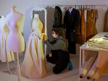 Una trabajadora coloca un traje durante los preparativos de la exposición 'Cornejo, el sastre de Galdós', en los Teatros del Canal en Madrid