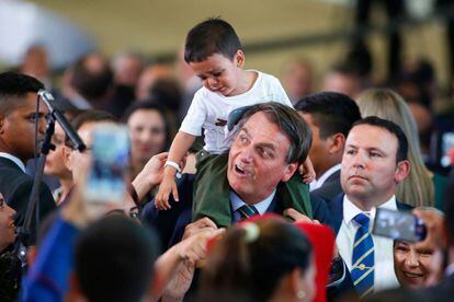 El presidente Bolsonaro carga a un niño venezolano. 