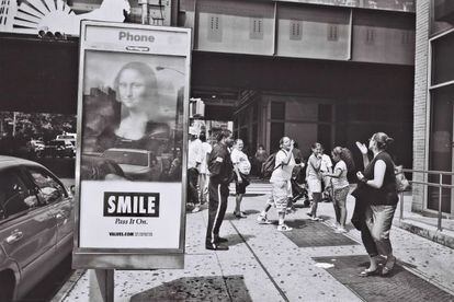 Un grupo de mujeres discuten en mitad de una de las calles de Queens. Un policía las observa, mientras un cartel anunciador con la 'Mona Lisa' invita a sonreír.