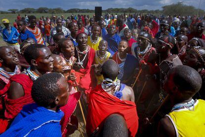 Un grupo de jóvenes hombres masai cantan y bailan en círculo para celebrar la victoria de su manyatta (pueblo) durante los Juegos Olímpicos de Maasai 2014, celebrado en la aldea Kimana cerca de la frontera con Tanzania, junto al Parque Nacional de Amboseli, en Kenia, el 13 de diciembre de 2014. Los cientos de jóvenes hombres masai que representan cuatro manyattas (pueblos) compitieron en seis partidos para ganar medallas, premios en efectivo o un toro de cría.
