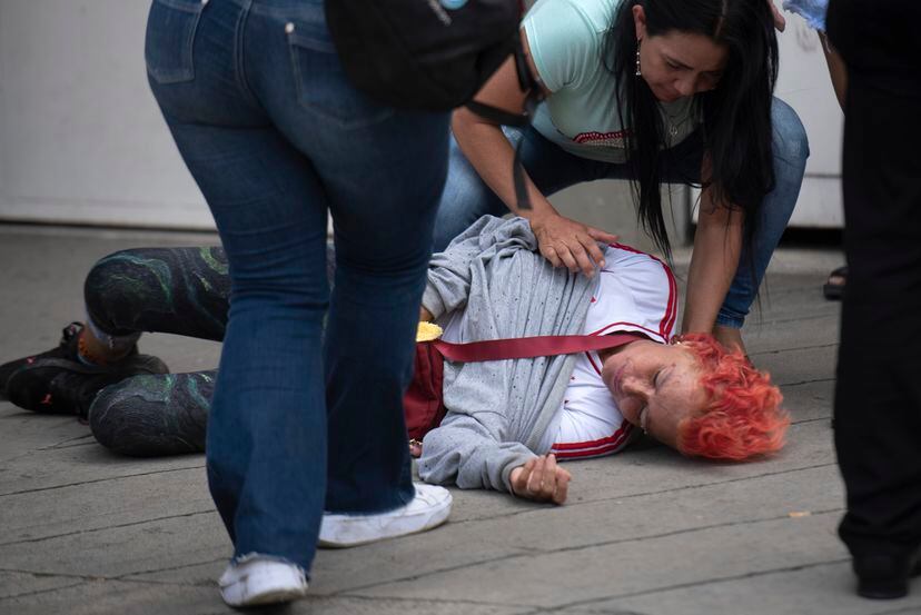 Dos mujeres atienden a una mujer que se desmayó.