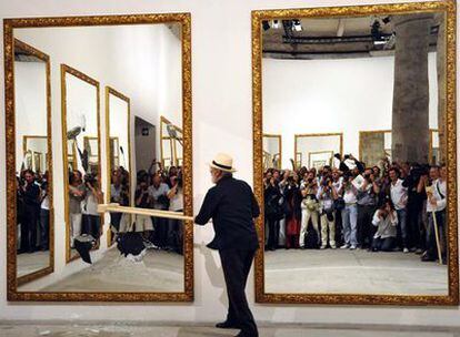 El artista Michelangelo Pistoletto rompe uno de los espejos de su instalación/<i>performance</i> en la Bienal de Venecia.