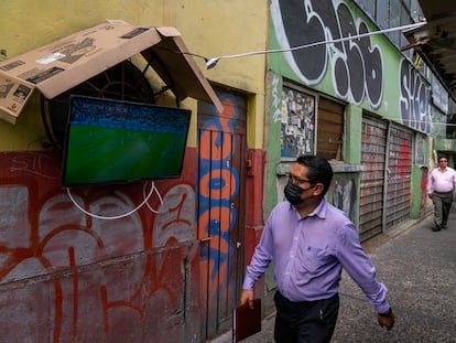 Un hombre mira un partido de fútbol televisado en un puesto callejero, en Ciudad de México, en noviembre de 2022.