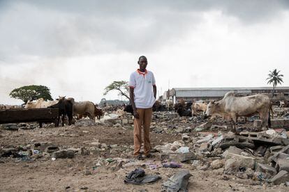 Adama Dramé poses in January 2020 in the Abattoir neighborhood (Abidjan) on the ruins of his electrician business, demolished in July 2018.