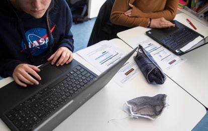 Dos alumnas utilizan ordenadores portátiles para un trabajo escolar.