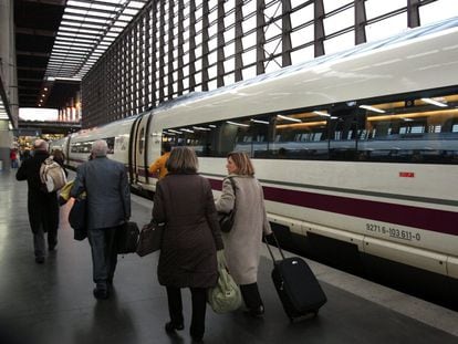 Varios pasajeros con maletas bajan del AVE en la estación de Atocha (Madrid).