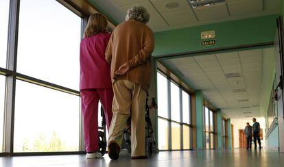 Una trabajadora pasea junto a una anciana en el centro de referencia de atención a personas con alzhéimer y demencia, en Salamanca.  