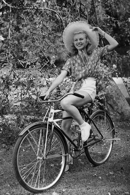 La ganadora de un Oscar Ginger Rogers nos inspira con el estilismo perfecto para dar un paseo en bici siguiendo el espíritu viejo Hollywood: sombrero de paja, camisa anudada y pantalones cortos.